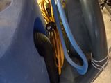 a blue cart with a hose and a blue bag on it