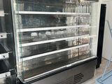 a display case in the middle of a store filled with food