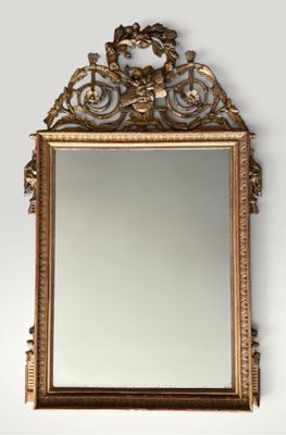an ornate gold framed mirror on a wall next to a white wall