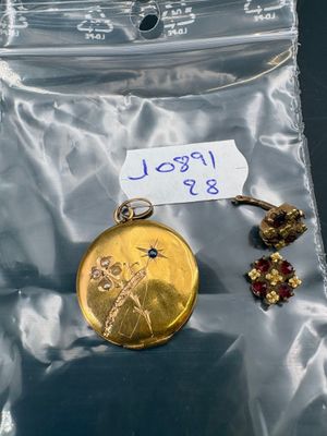 a small gold pocket watch in a plastic bag