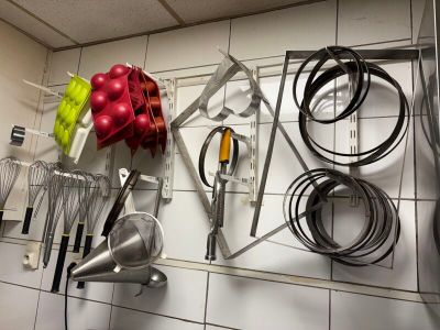 many kitchen utensils hanging on the wall in the kitchen