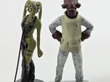 two figurines of a man and a woman standing next to each other