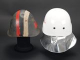 two helmets are sitting next to each other on a black surface