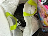 a bag full of items sitting on the floor next to a microwave