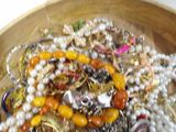 a wooden bowl filled with lots of different colored beads