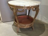 une petite table au plateau en marbre, dans un coin de la pièce