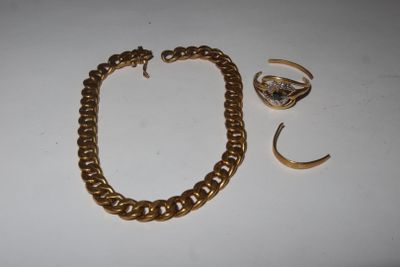 a close up of a gold bracelet and ring on a table