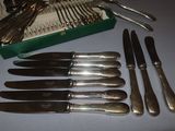 a lot of silverware on a table with a green box
