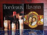 deux livres posés sur une table, à côté d'une bouteille de vin