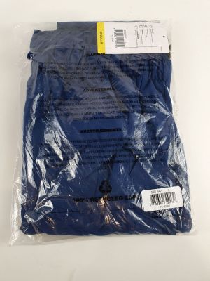 un gros plan d'une chemise bleue emballée dans du plastique posée sur une surface blanche