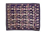 un tapis bleu et rose orné de fleurs et de feuilles