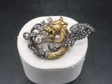 a close up of a gold and silver ring with a bird on it