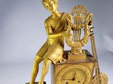 a gold statue of a woman playing a musical instrument