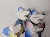 three small figurines of birds on a table