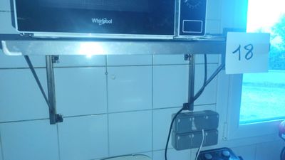 a microwave that is sitting on a shelf above a sink