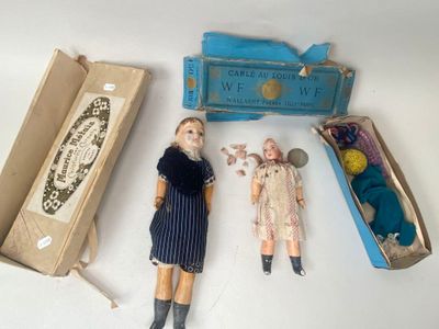 two dolls that are sitting next to a box