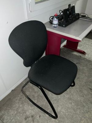 une chaise de bureau noire posée à côté d'un bureau blanc