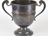 une coupe en argent posée sur un socle