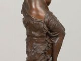 statue of a man sitting on a rock with his hands on his face