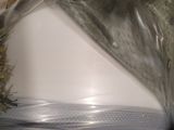 a white toilet in a plastic bag on the floor