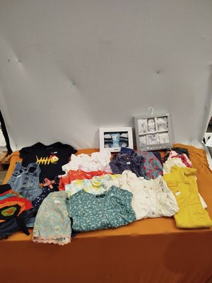 une table sur laquelle sont posés tout un tas de vêtements pour bébés