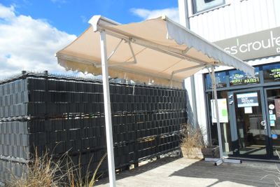 a white awning over a store front with black crates