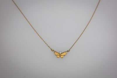 un collier avec un papillon doré sur fond blanc