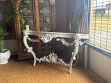 a white table with a mirror and a potted plant