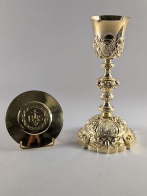 une assiette en argent avec une tasse en argent et une assiette en argent posées sur un fond blanc