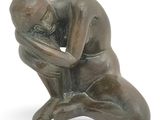 statue of a kneeling man holding his head in his hands