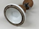 a close up of a vase with a handle on a table