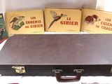 quatre livres posés sur la table, à côté d'une valise