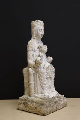 an old statue of a woman holding a child on a table