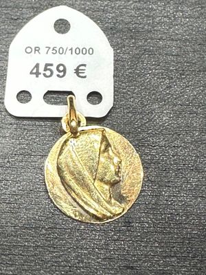 l'image d'une médaille d'or sur laquelle figure le visage d'une femme
