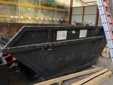 a black dumpster sitting in the middle of a building