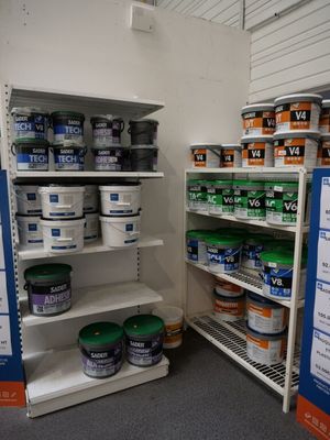 de nombreux pots de peinture sur les étagères du magasin