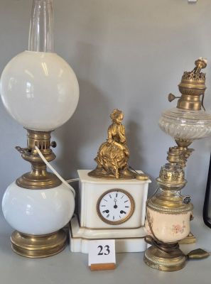 a lot of antique lamps and a clock on a table