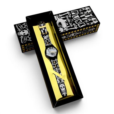 une boîte avec une montre à l'intérieur sur une surface blanche
