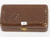 an old wooden box with a tag on it sitting on a white surface