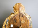une statue en bois représentant un homme avec un oiseau sur le dos