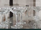 several empty wine glasses sitting on a glass table in front of a mirror