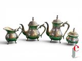 three pieces of silver and green teapots on a white surface