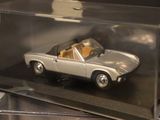 a silver toy car in a clear box on a table