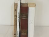 trois livres posés l'un à côté de l'autre sur une table