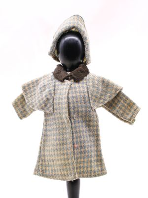 une poupée vêtue d'un manteau et d'un chapeau