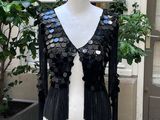 un mannequin recouvert de paillettes devant une vitrine