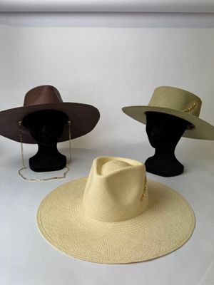 trois chapeaux exposés dans une pièce blanche sur fond blanc