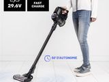 the woman is using a cordless vacuum cleaner to clean the floor