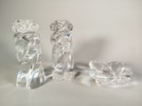 trois figurines en verre transparent posées sur une surface blanche