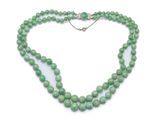 gros plan d'un collier de perles vertes sur fond blanc